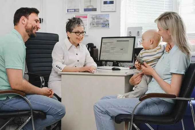 A family with a baby meeting a clinician in a consulting room
