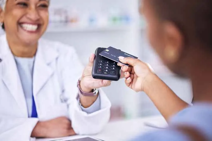 A pharmacist taking a card payment at the counter